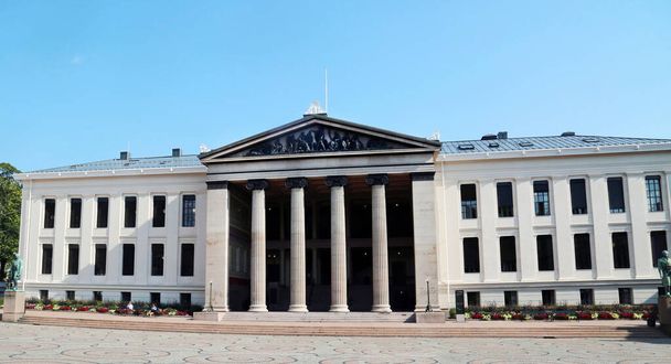 View of the University of Oslo (norv. Universitetet i Oslo) on a clear sunny day against a blue clear sky, Norway. Travel landscape sights of Europe. - 写真・画像