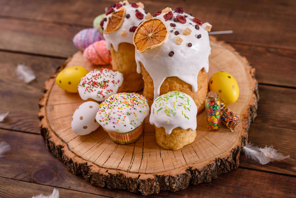 Pasteles festivos con glaseado blanco, nueces y pasas en la mesa festiva. Preparativos para la Pascua - Foto, imagen