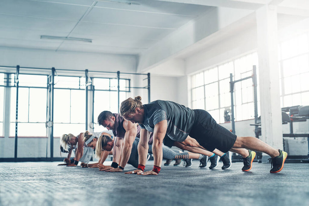Push yourself a little further each day. Shot of an accountability group working out at the gym. - Foto, imagen