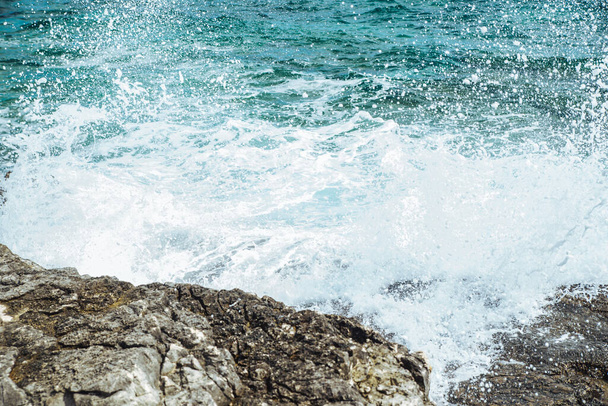 uitzicht op water met golven met rotsachtige klif. kopieerruimte - Foto, afbeelding