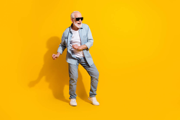 Full length body size view of attractive cheerful funky grey-haired man dancing isolated over vivid yellow color background - Photo, image