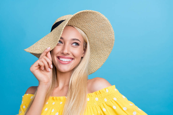 Photo of sweet millennial blong lady look promo wear yellow top cap isolated on blue color background - Fotoğraf, Görsel