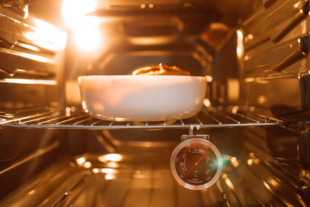 Kana paistetaan uunissa lasipannulla. Kotitekoinen ruoka. Uunin lämpötila ruoanlaittoon uudessa kaasuuunissa - Valokuva, kuva