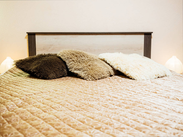 Un lit confectionné avec des oreillers moelleux et un couvre-lit matelassé. Concentration douce - Photo, image