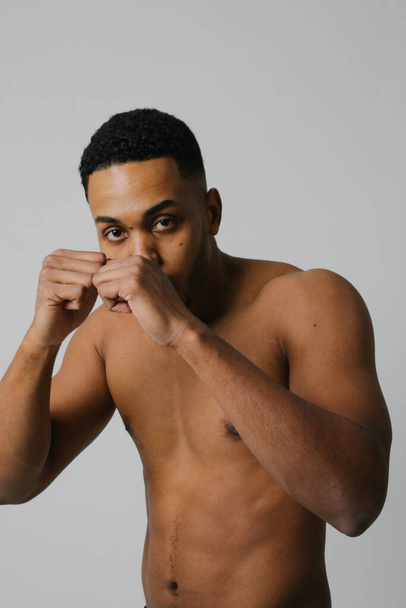 Headshot of confident young black male boxer practicing boxing in studio. - 写真・画像