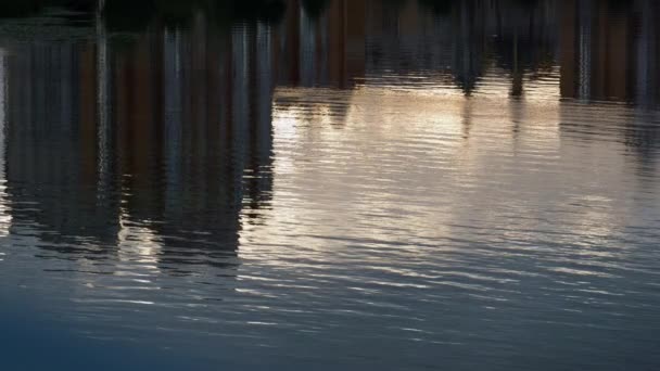 Agua reflejando edificios de paisaje urbano tiro de dron. Calma ondulado río que fluye superficie - Metraje, vídeo