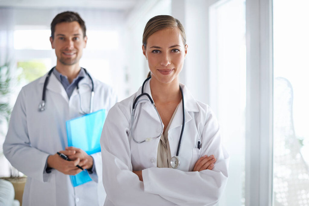 Váš lékařský tým. Portrét dvou usmívajících se doktorů stojících v nemocnici. - Fotografie, Obrázek