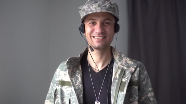 Mozgókép fiatal boldog mosolygós férfi katona álcázott katonai egyenruhában csinál technológia videó hívás a családja vagy barátai csak forduljon haza után küldetés. - Felvétel, videó