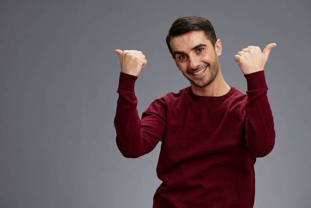Hombre alegre mostrando pulgares arriba en un suéter posando emociones gesto de la mano - Foto, Imagen