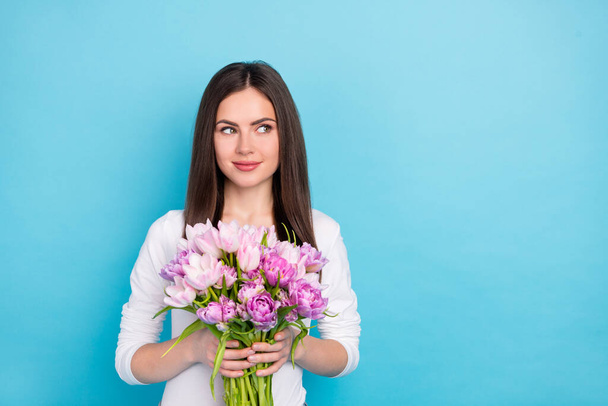 Portrait of attractive cheery minded girl holding flowers thinking copy blank space isolated over brigth blue color background - Fotografie, Obrázek
