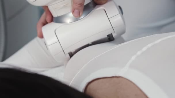Junge Brünette erhält elektrische Massage auf ihrem Körper in einem speziellen Anzug - Filmmaterial, Video