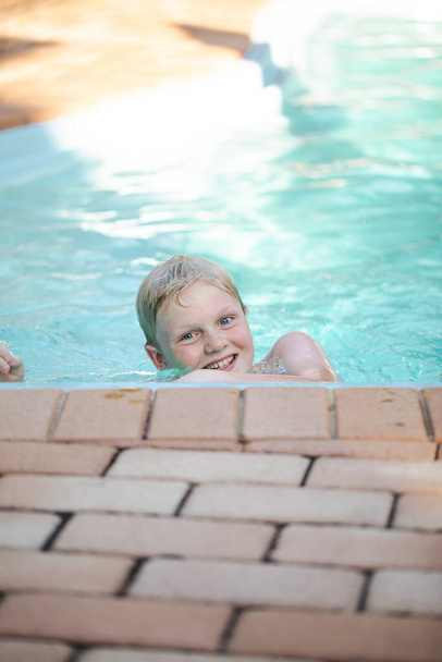 Щасливий перед підлітком хлопчик плаває у басейні на задньому дворі
 - Фото, зображення