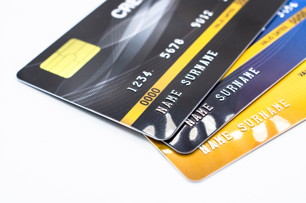 Großaufnahme einer Reihe von Kreditkarten isoliert auf weißem Hintergrund. Kreditkarte ermöglicht Kreditkarteninhabern Kredite aufzunehmen, mit denen sie Waren und Dienstleistungen bezahlen können, abhängig von der Bedingung, dass Karteninhaber Geld zurückzahlen. - Foto, Bild