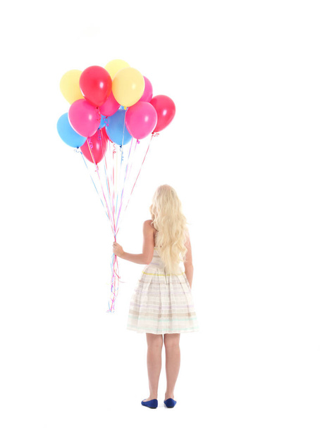 Ganztägiges Porträt eines blonden Mädchens im Partykleid, das ein Bündel bunter Luftballons in der Hand hält. Isoliert auf weißem Studiohintergrund - Foto, Bild