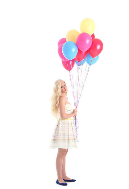 Portrait complet de fille blonde portant une robe de soirée, tenant un tas de ballons colorés. Isolé sur fond de studio blanc - Photo, image