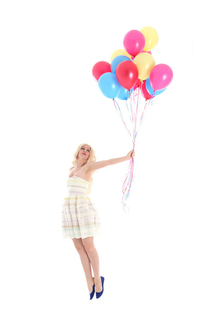 Full length portrait of blonde girl wearing party dress, holding bunch of colourful balloons. Isolated on white studio background - Zdjęcie, obraz