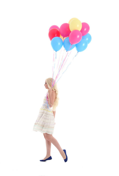 Full length portrait of blonde girl wearing party dress, holding bunch of colourful balloons. Isolated on white studio background - Fotografie, Obrázek