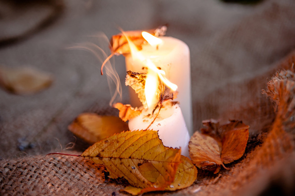 Droge esdoorn bladeren en warme kaarsen licht - Foto, afbeelding