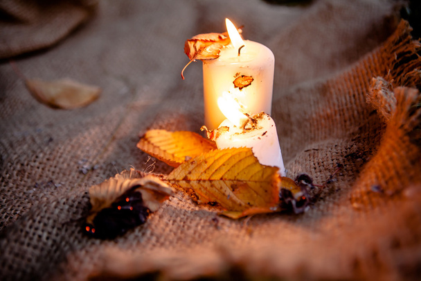 Feuilles d'érable sèches et bougies chaudes lumière
 - Photo, image