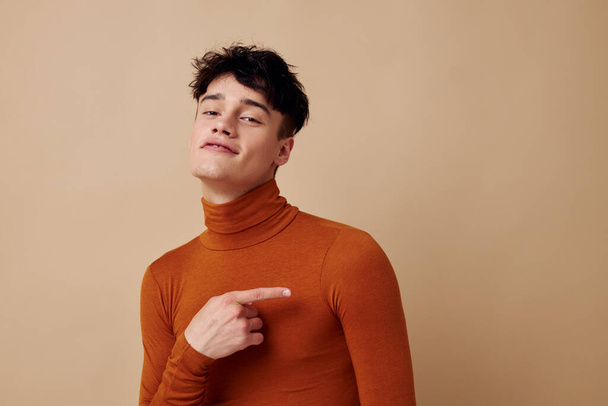 schöner Kerl posiert in braunem Pullover Selbstbewusstsein Mode isoliert Hintergrund unverändert - Foto, Bild