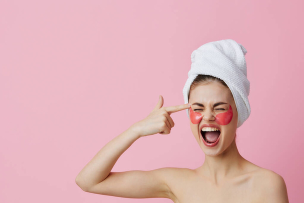 portrait woman pink patches on the face with a towel on the head pink background - Photo, Image