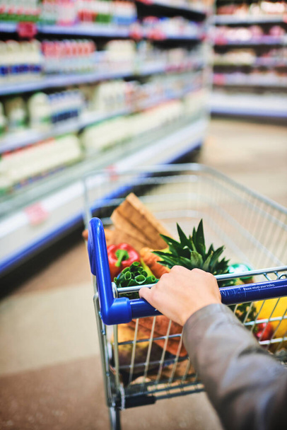 The best stock is fresh stock. Cropped shot of a woman pushing a trolley while shopping at a grocery store. - Foto, imagen