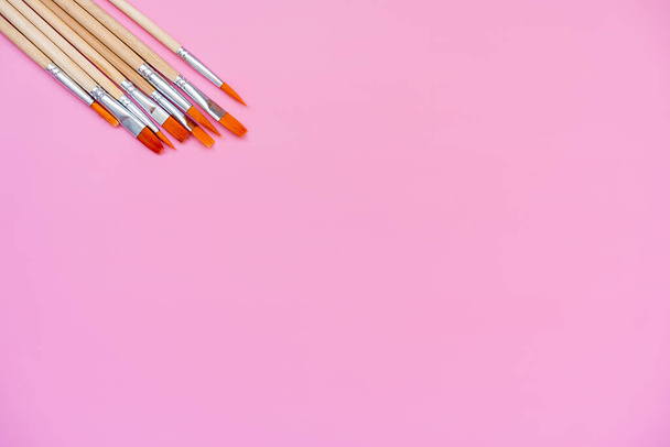 set of paint brushes on a pink background, top view, flat lay, space for text  - Fotoğraf, Görsel