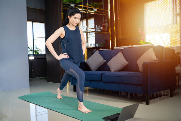 Aasialainen nainen tekee liikuntaa koulutusta verkossa kotona - Valokuva, kuva