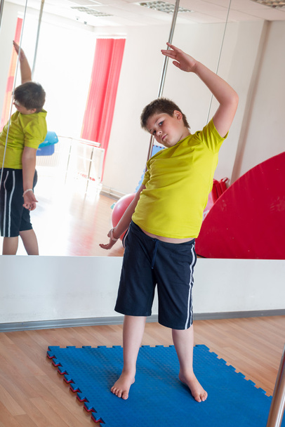 Boy does exercise  in the gym - Foto, afbeelding