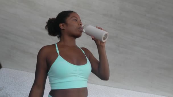 Junge Afrikanerin macht Pause und trinkt Wasser bei Workout-Übungen im Freien - Lifestyle-Konzept der Sportmenschen - Filmmaterial, Video