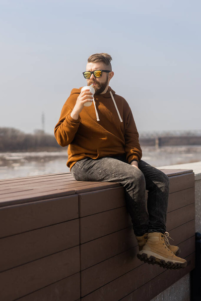 Κομψός όμορφος hipster άντρας κρατώντας ποτά κοκτέιλ, την άνοιξη - Φωτογραφία, εικόνα