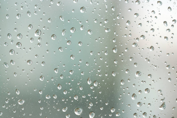    Raindrops on a window pane during rainy weather                             - Photo, Image