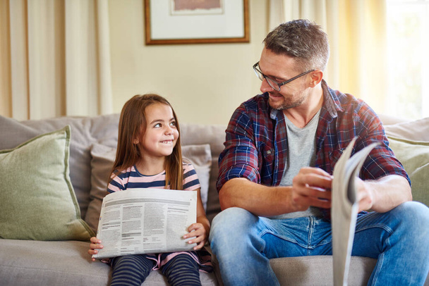 Бути твоїм батьком - моя улюблена робота. Знімок батька і дочки, що читає газету
. - Фото, зображення
