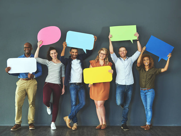We all have an opinion that matters. Studio shot of a diverse group of people holding up speech bubbles against a gray background. - Foto, imagen