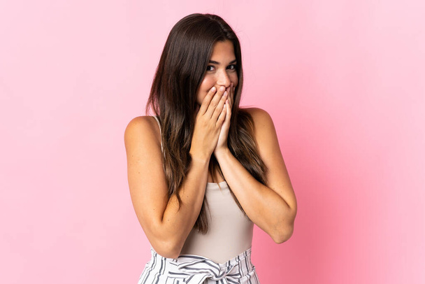 Young brazilian woman isolated on pink background happy and smiling covering mouth with hands - Фото, изображение