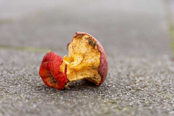 an old bitten apple on a street in selective focus - Photo, Image
