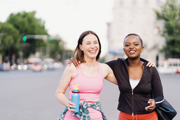 Dvě multietnické dívky procházky na cvičení, venkovní komunikace. - Fotografie, Obrázek