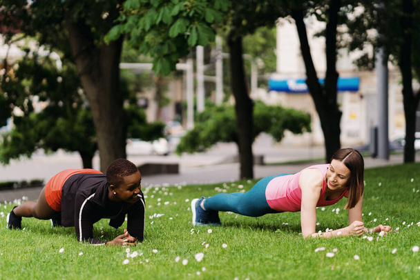 Zwei schöne Frauen beim Planken auf dem Stadtplatz beim Sport - Foto, Bild