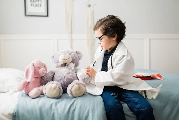 Мріє стати лікарем. Чарівний хлопчик хоче кар'єру в медицині і грає з плюшевими ведмедями як пацієнти
 - Фото, зображення