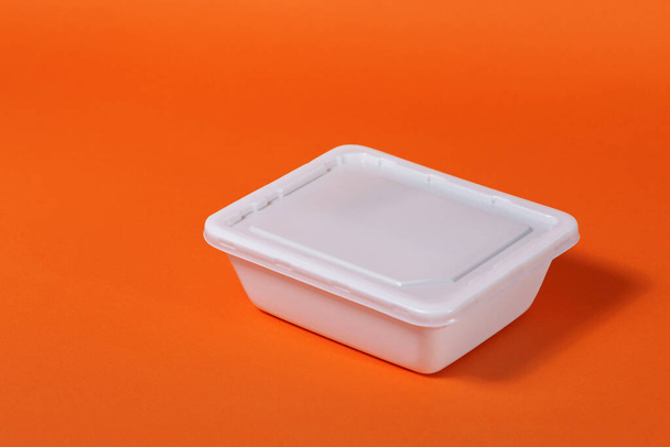 White plastic fast food box on orange background - side view, isolate - Photo, image