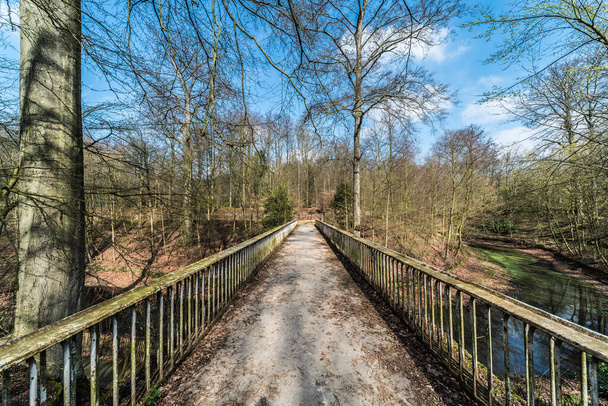 Egyenes vonalak egy elhagyatott keskeny gyalogos hídról az Ossegem városi park völgye felett Laekenben, Brüsszelben, Belgiumban - Fotó, kép
