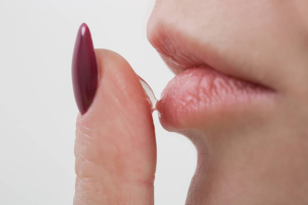 Закрыть женщину, наносящую бальзам для губ или маску для губ. - Фото, изображение