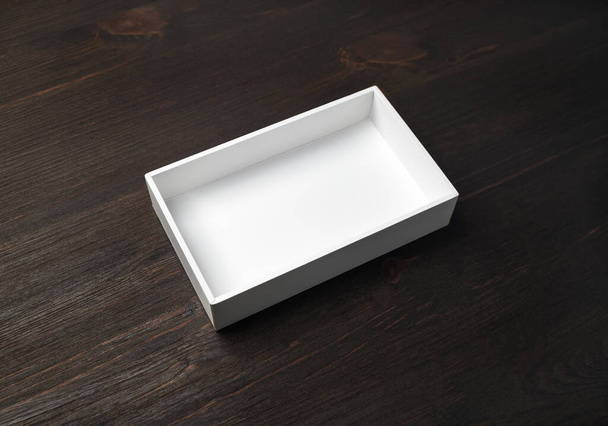 Una maqueta de caja en blanco. Caja de papel blanco sobre fondo de mesa de madera. Maqueta de branding. - Foto, Imagen