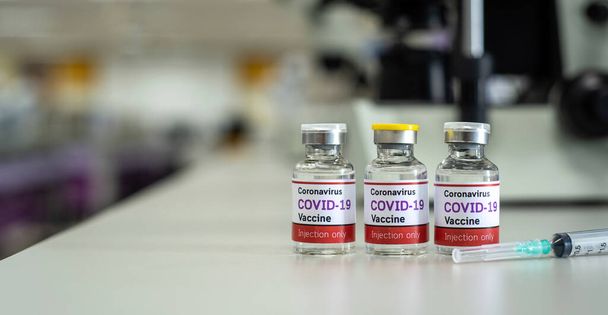 Concept vaccin tegen covid-19 coronavirus Omicron BA.2, een fles vaccin in een wetenschappelijk laboratorium dat een prototype is voor uitvinding en ontwikkeling. - Foto, afbeelding