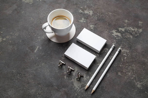 Branding mock up. Photo of blank business cards, pencils, coffee cup and clips on concrete background. - Foto, Imagen