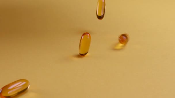 Oméga huile de poisson complément alimentaire tombant sur fond jaune. Oméga huile de poisson softgels complément alimentaire fond. Vie saine et concept de santé cardiaque. - Séquence, vidéo