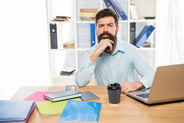 Serious manager thinking sitting at office desk at workplace - Foto, Imagen