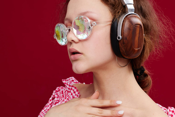 girl wearing headphones glasses with diamond close-up red background unaltered - Φωτογραφία, εικόνα