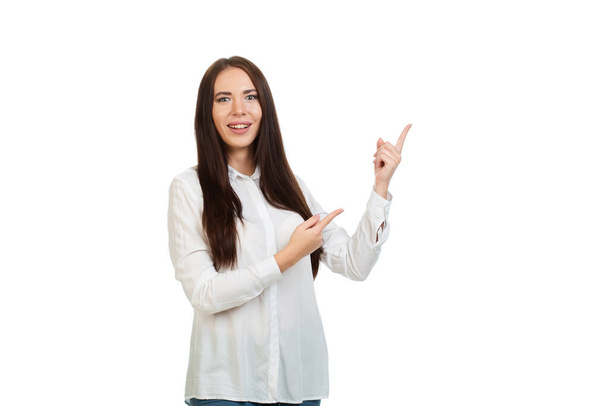 Young, beautiful girl isolated on a white background, points his fingers at the place for promo, offers or advertising. - Photo, Image