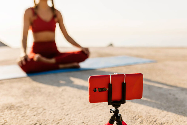 Instruktorin unterrichtet online Yoga-Unterricht durch Videoanruf am Telefon - Foto, Bild